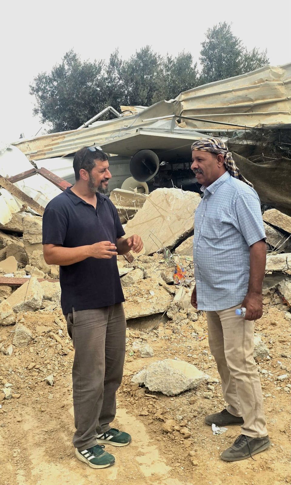 נתי יפת משוחח עם תושב בין הריסות מבנים בכפר בנגב